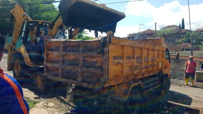 Alat berat dikerahkan oleh Kades Samarang untuk mengeruk sampah di tanah carik
