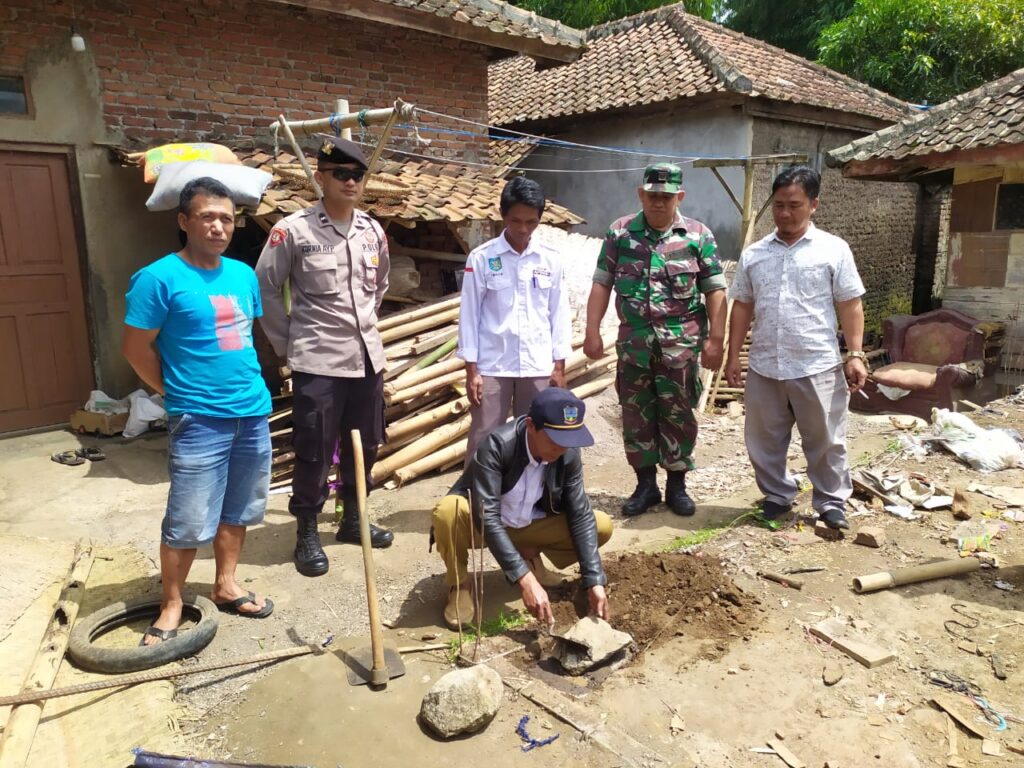 Kades Sukasenang Heriawan melakukan peletakan batu pertama dihadiri Babinsa, Bhabinkamtibmas dan tokoh masyarakat