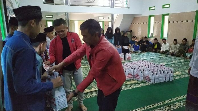 Sekretaris dan wakil ketua DPC PDI Perjuangan Garut mewakili Anggota DPRD Garut Yudha Puja Turnawan memberikan santunan uang tunai dan sembako kepada anak yatim dan janda tua di Parakan Samarang